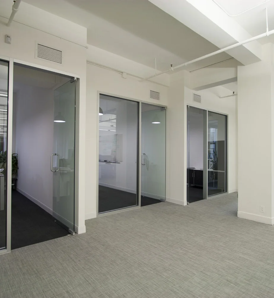 Black-framed glass office front in a bright commercial workspace