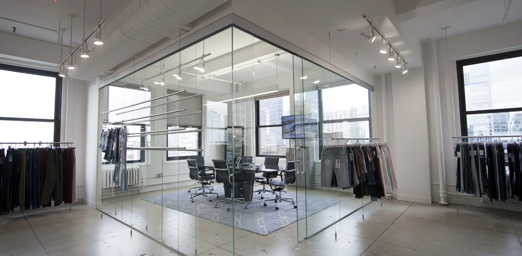 Glass conference room within a light-filled fashion showroom