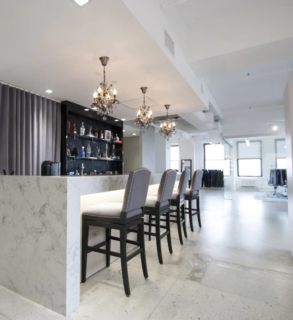 Marble-front hospitality bar with pendant lights in a commercial lounge